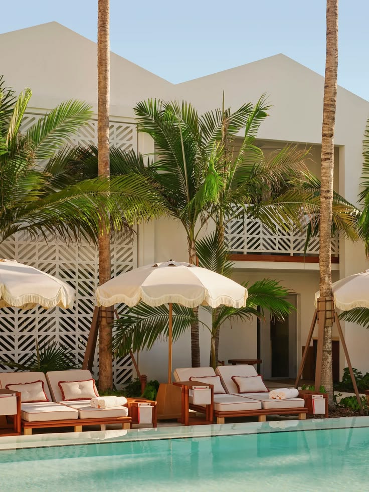 Hotel met palmen en ligbedden aan het zwembad
